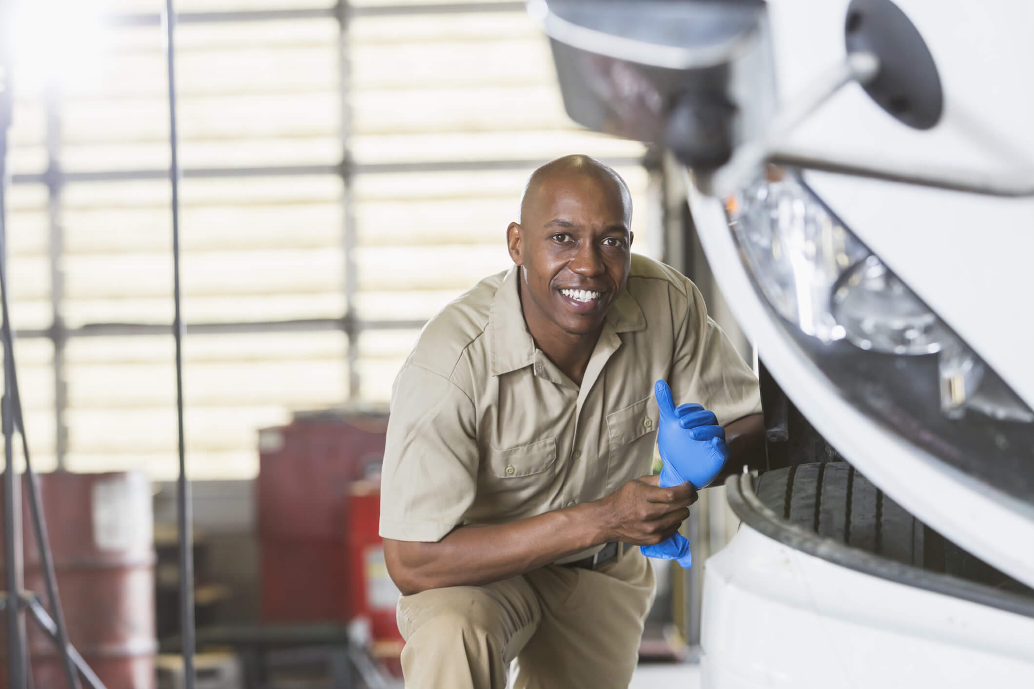 A man works on repairs to a shipping truck