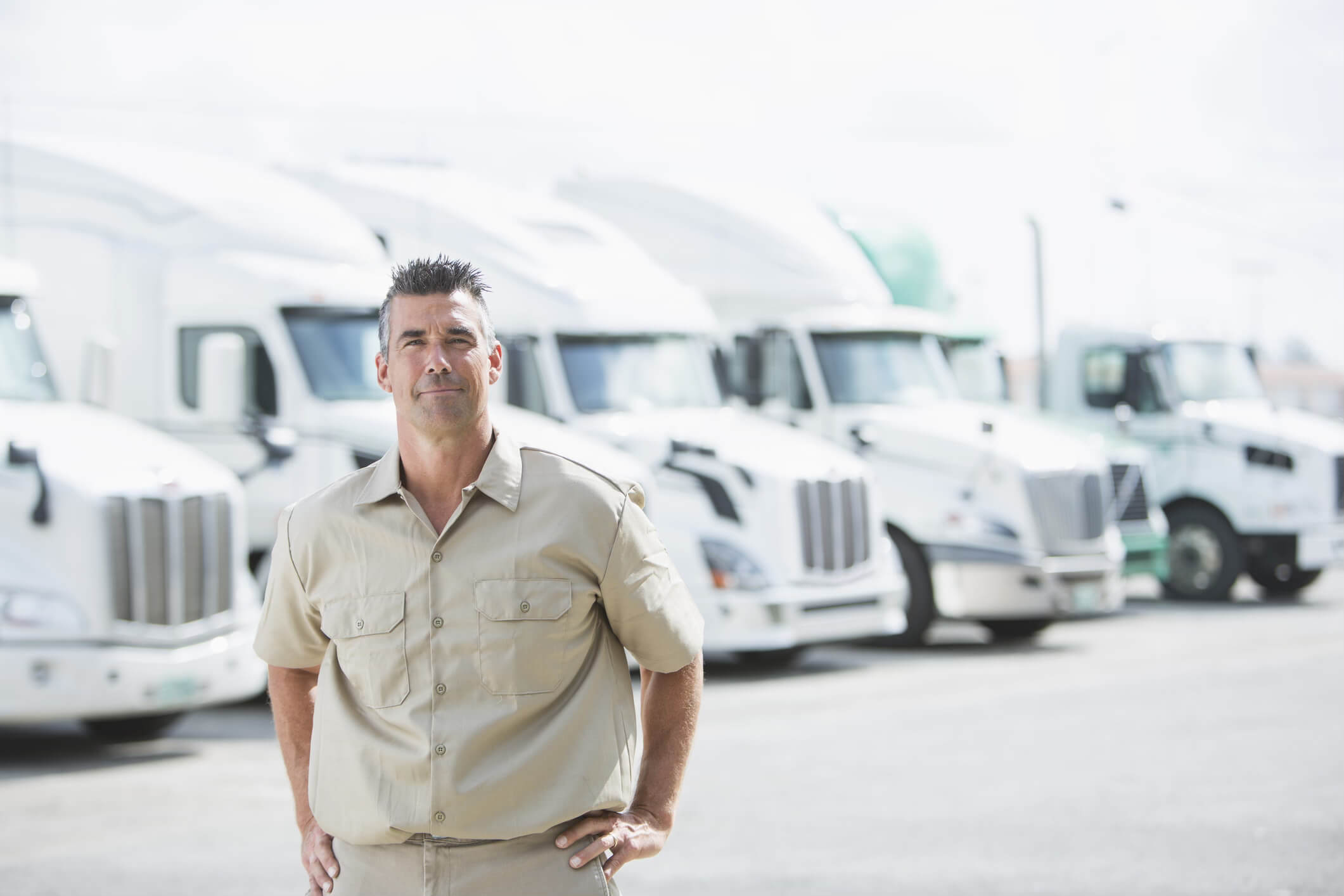 A man standing in front of shipping trucks